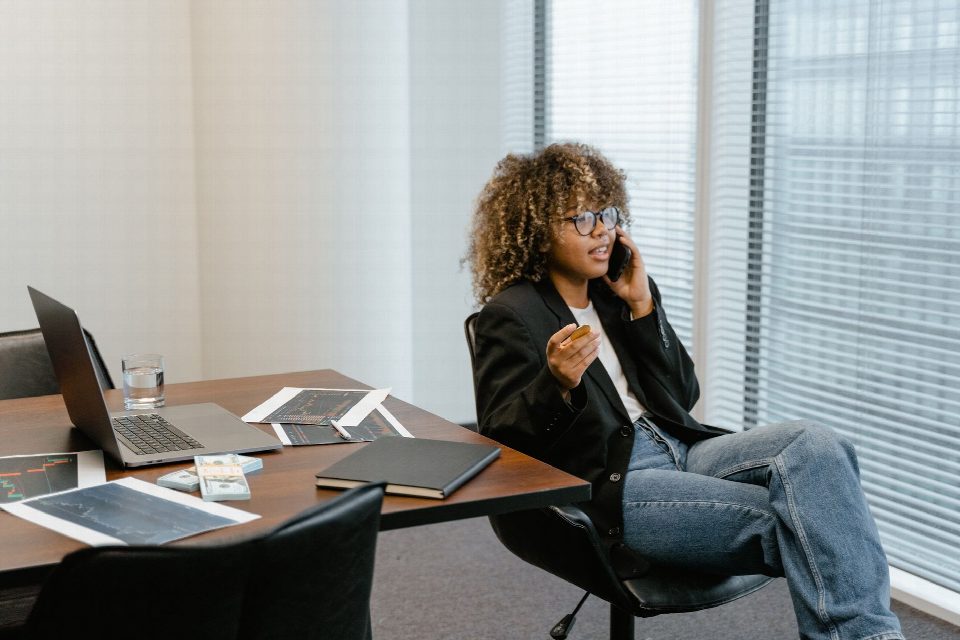 A business analyst engaged in work, sitting at a desk with a laptop and graphs. A business analyst engaged in work, sitting at a desk with a laptop and graphs.